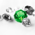 Green gemstone among colorless gemstones